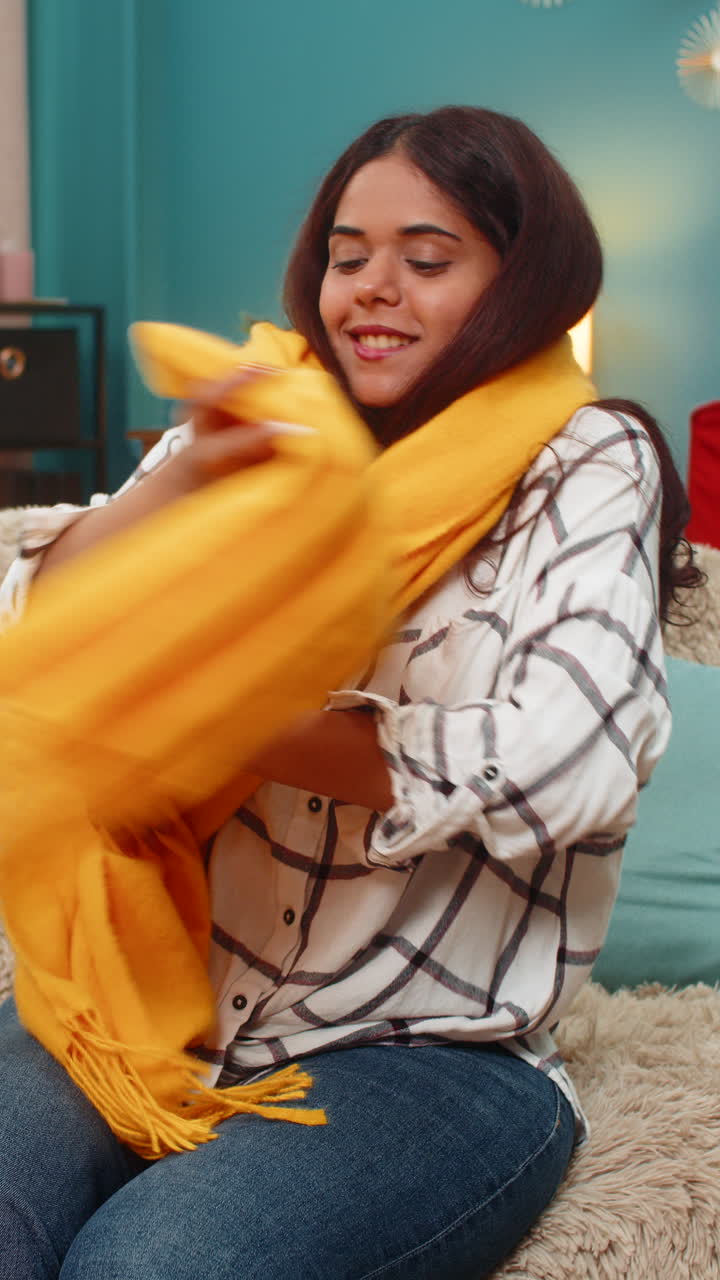 Indian woman unboxes delivery box finds new scarf smiles joy celebrating successful online shopping