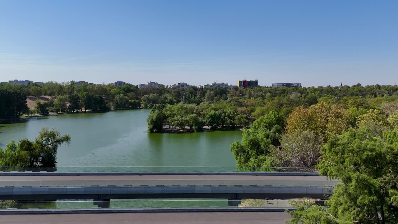 Aerial Shot of Tineretului Park, Highlighting a Bridge and a Small Lake Amidst Greenery, Bucharest, Romania