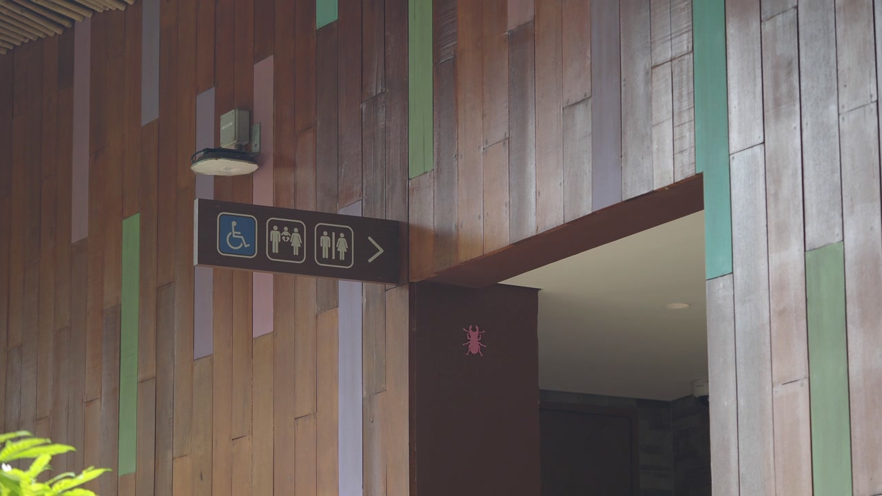Modern Public Restroom Sign on a Colorful Wooden Wall