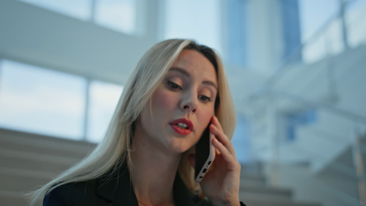 Blonde manager talking mobile phone holding papers closeup. Woman discussing