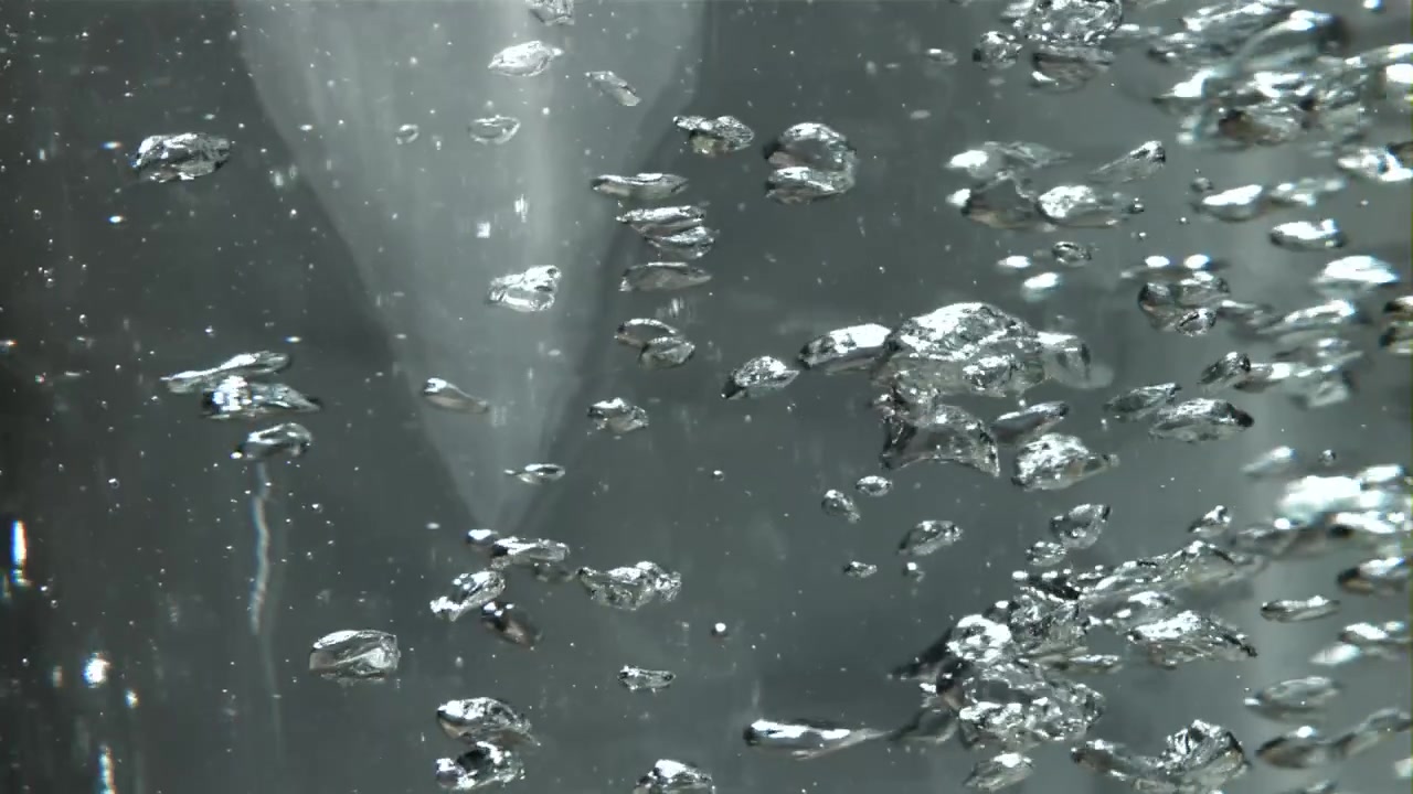 Ripresa macro di bolle effervescenti che salgono in acqua limpida
