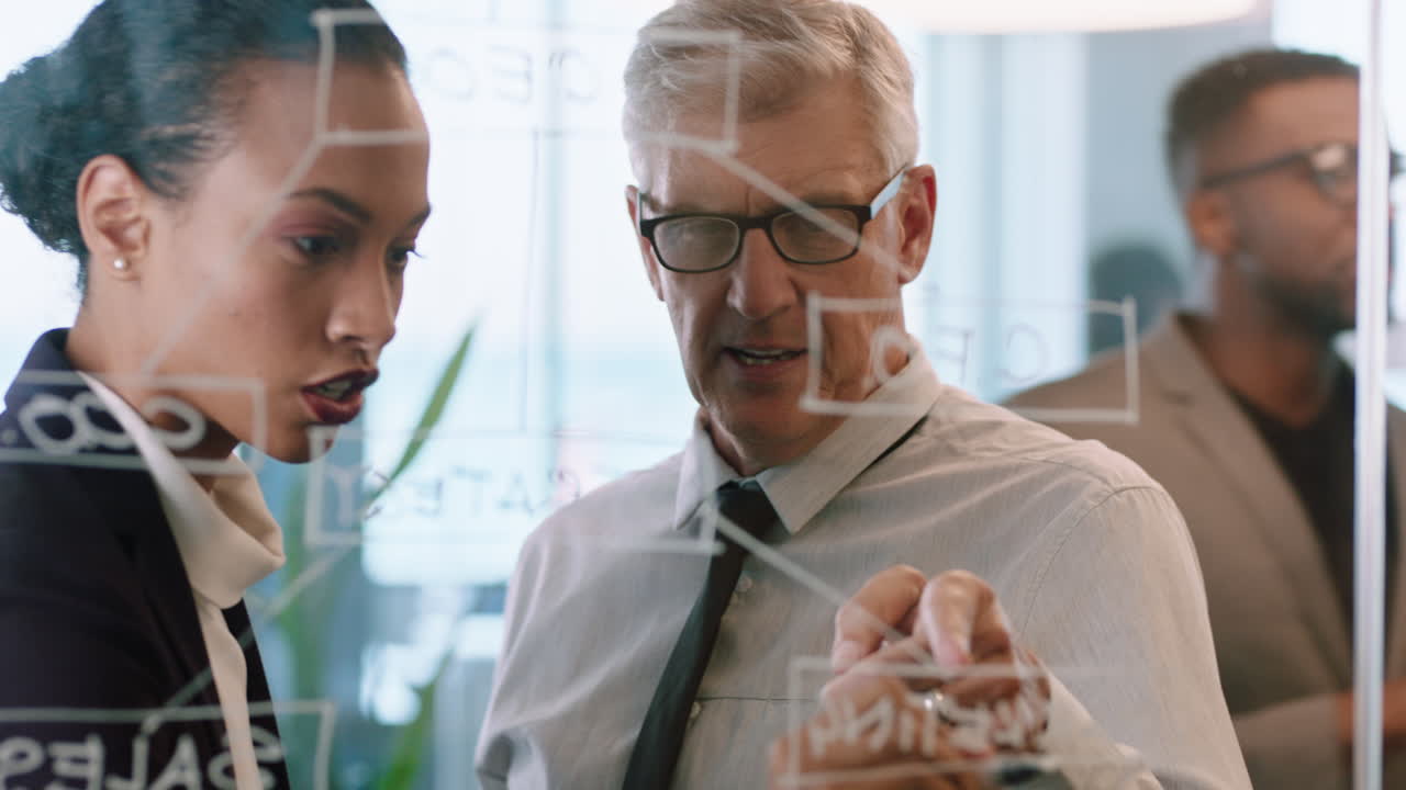 ⁇ 적 ⁇ 적한 메모를 사용하는 사업가들 브레인스토밍 팀 리더 여성은 유리 화이트보드에 글을 쓰고 동료들과 함께 사무실 회의에서 문제 해결 전략을 보여줍니다.