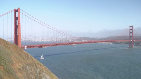 panorama view of the golden gate bridge and san francisco downtown and a ship crossing the bridge