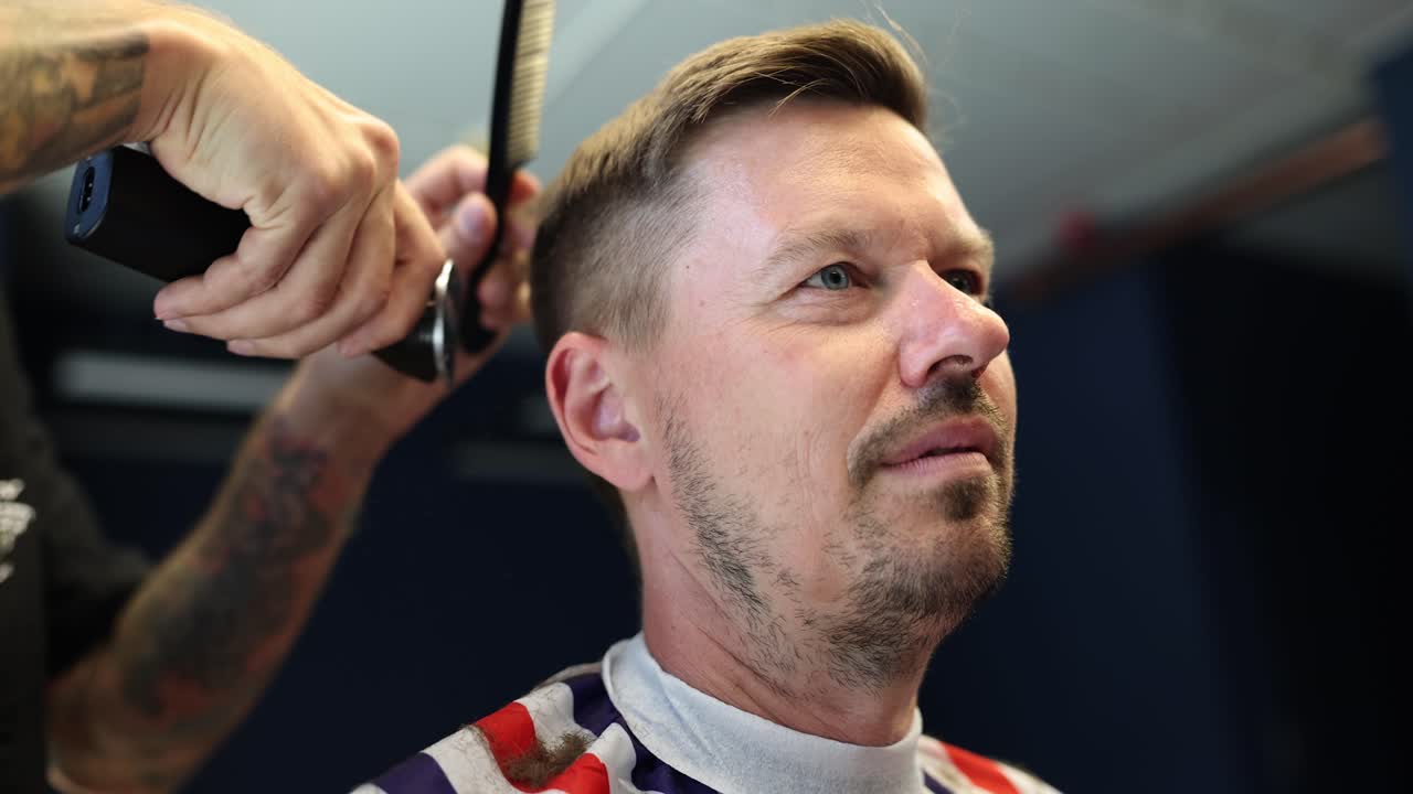 un hombre se corta el cabello en una barbería.