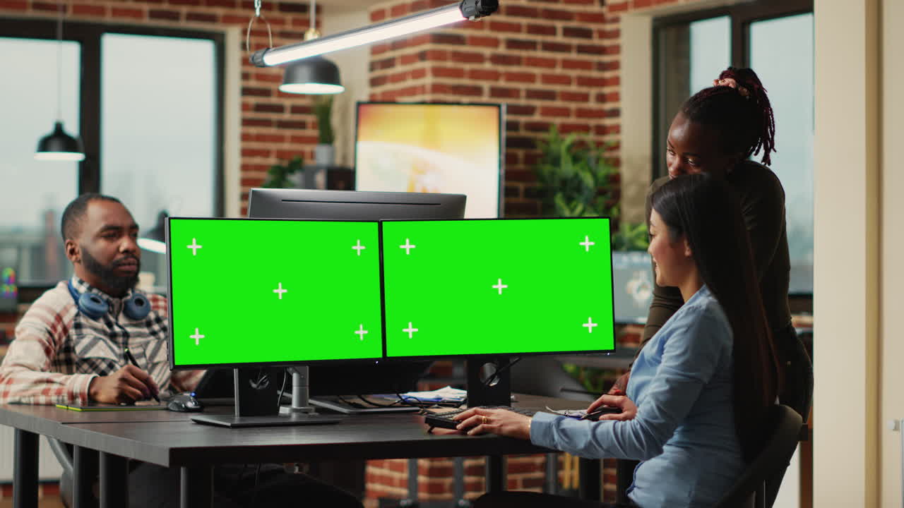 Team of diverse workers analyzing computers with greenscreen template