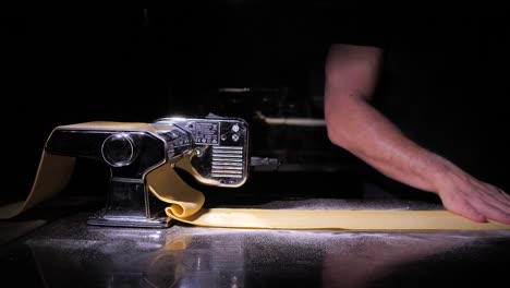 unrecognizable man making fresh homemade lasagne pasta, isolated on black background