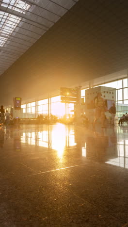 passengers walking in airport terminal with afternoon sunlight in vertical