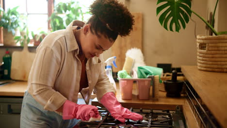 woman cleaning stovetop in kitchen