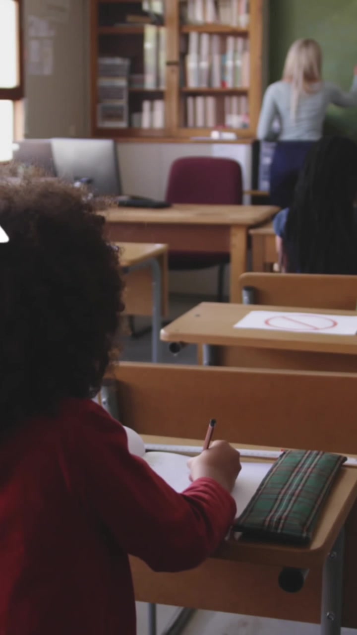 Animazione di icone multiple sulla vista posteriore di un insegnante che istruisce gli studenti in classe.