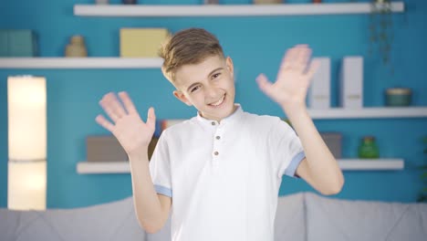 happy and cute boy waving at camera.