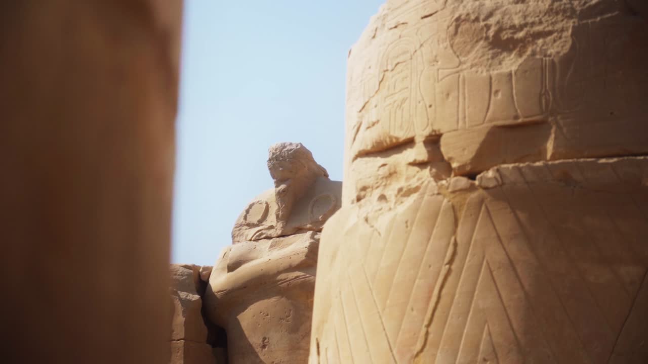 Intricate carved drawings and hieroglyphs adorning the stone structures in the Karnak Temple, Luxor Egypt Slow slide movement sideways.