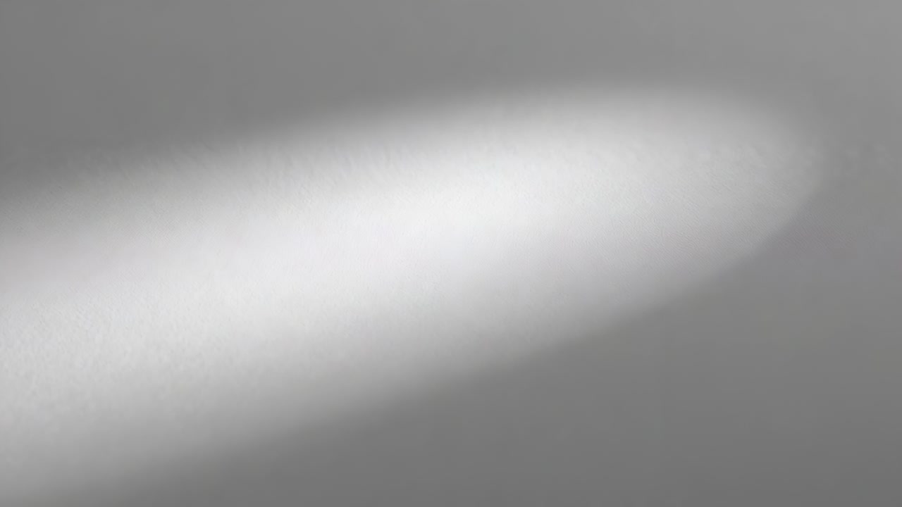 Appearing soft oval bright light patch shifting across room ceiling from moving beam, fading