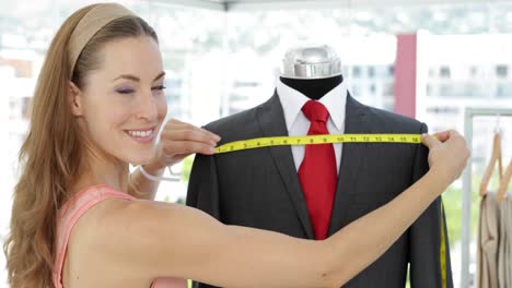 Pretty-fashion-designer-measuring-suit-on-mannequin