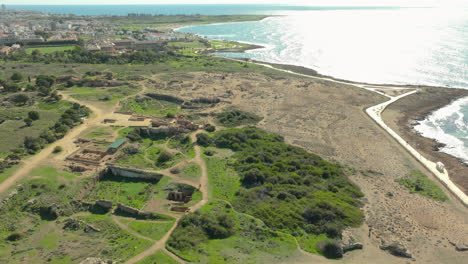 Overlooking-the-Tombs-of-the-Kings,-this-view-captures-the-contrast-between-the-ancient-burial-site-and-the-vivid-blue-of-the-Mediterranean,-with-visitors-exploring-the-expansive-historic-grounds