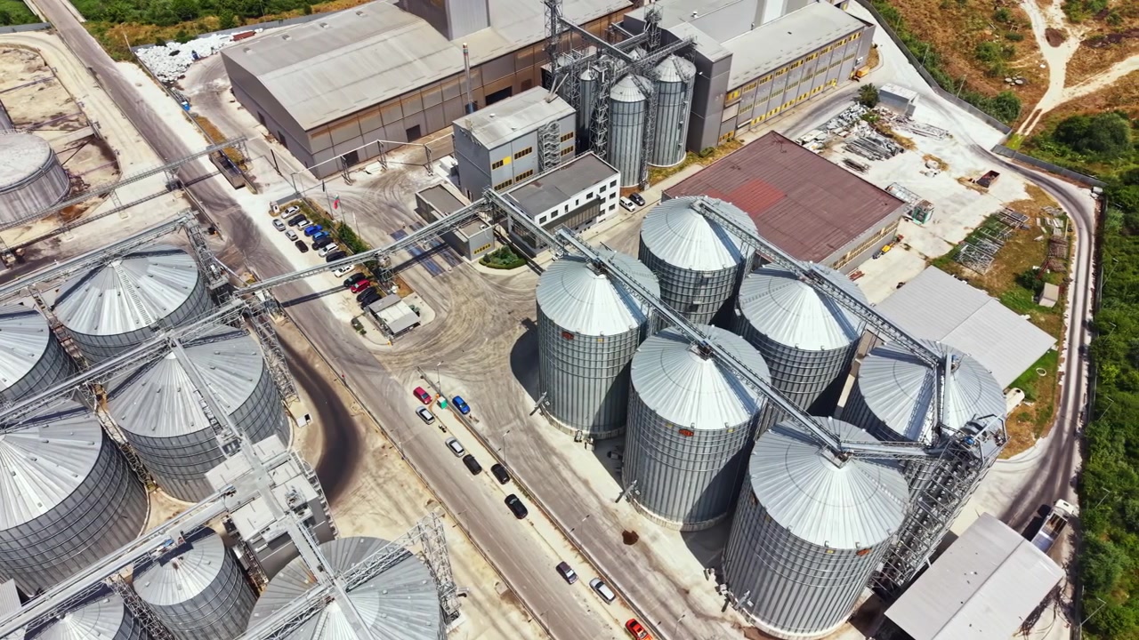 Industriestandort mit Lagersilos und Verarbeitungsanlage tagsüber.