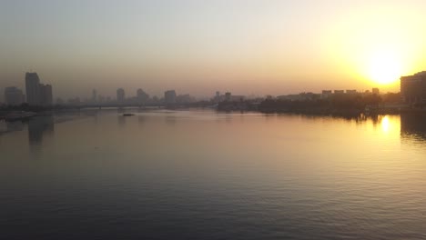 panorama view of river nile and cairo city skyline at sunset golden hour.hazy skyscrabers in the far background.