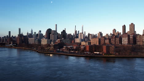 Aerial-view-over-the-East-river-towards-the-cityscape-of-Yorkville,-New-York,-USA