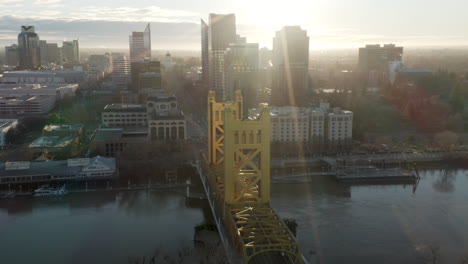 Aerial-drone-right-parallax-of-Tower-Bridge-and-Downtown-Sacramento,-CA,-including-Old-Sacramento---State-Capitol-in-background-during-sunrise