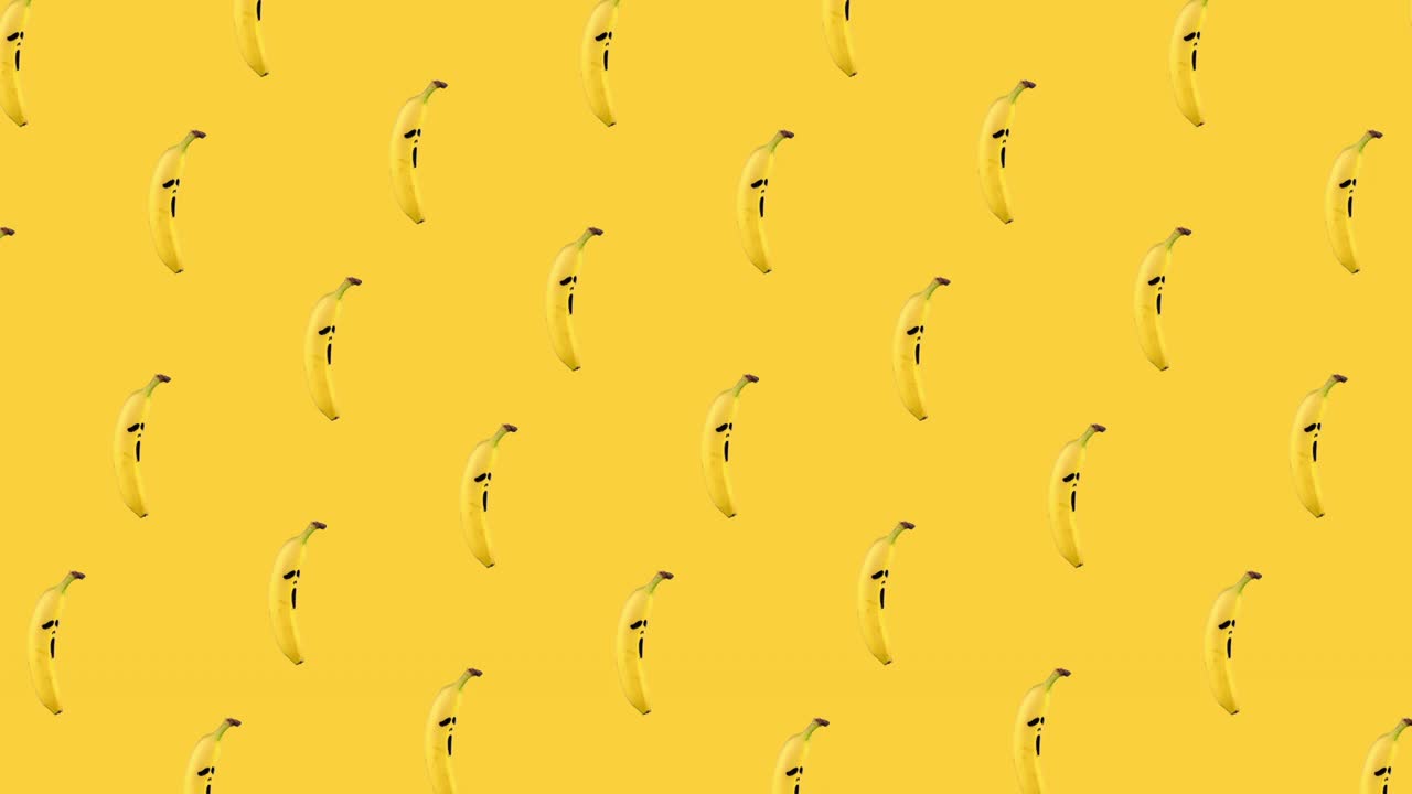 seamless looping animation pattern of bananas with painted on them scary mask of fear on a yellow background. Halloween concept for copy space