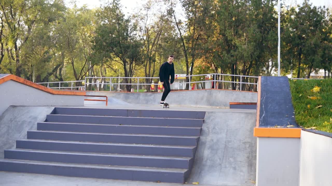 patinador hipster saltando por las escaleras en el skatepark. disparo en cámara lenta