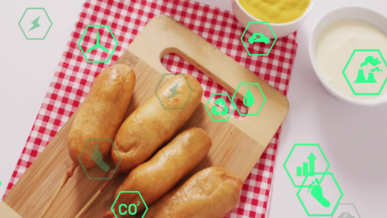 Icone esagonali verdi che compaiono ai bordi e si muovono su quattro salsicce infilzate su un tagliere che mostrano l'impatto ecologico