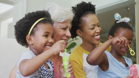 Feliz-Abuela-Afroamericana-Con-Hija-Adulta-Y-Nietas-Soplando-Burbujas