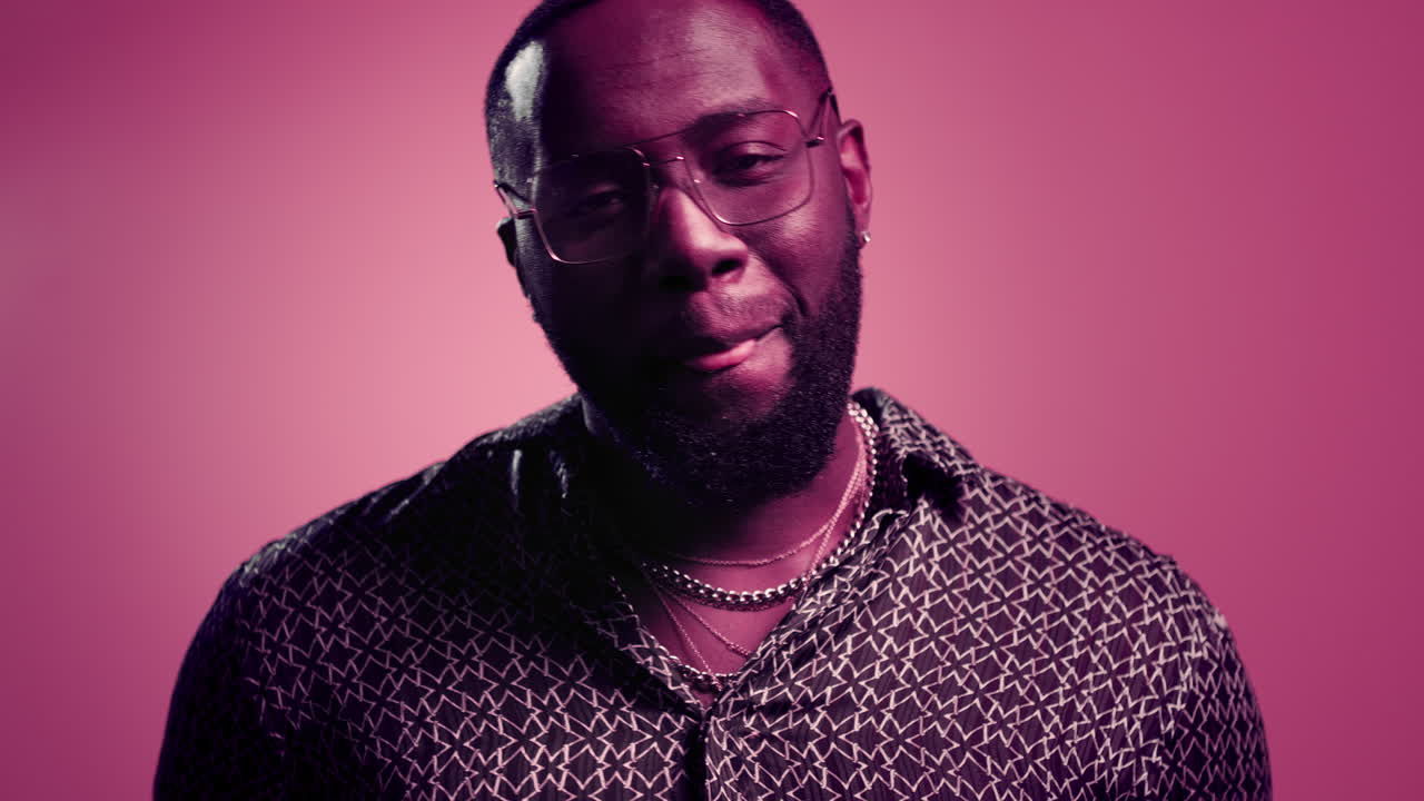 사랑스러운 아프리카 남자가 실내에서 공기 키스를 하고 있습니다. 아프리카 남자가 스튜디오에서 몸짓을 하고 있습니다.