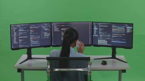 mujer programadora trabajando en múltiples monitores