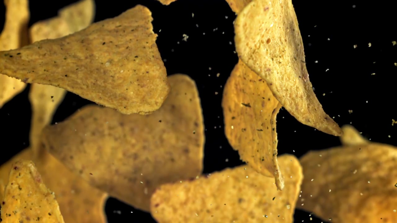 Gyllene tortillachips med kryddning som faller i slow motion