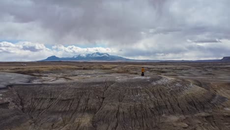 Anonymous-explorer-observing-mountainous-valley-from-hill-summit