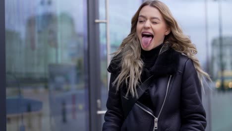 young woman riding electric scooter and winking in urban setting