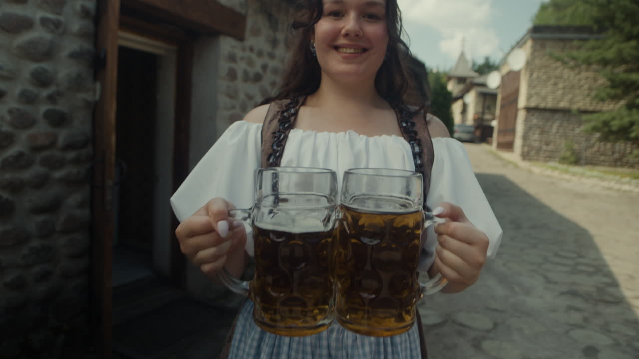 Woman in dirndl holding beer mugs