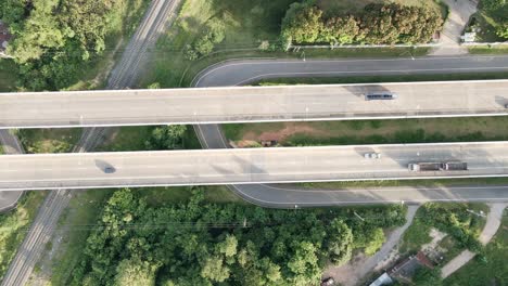 Top-aerial-view-following-car-on-railway-crossing-bridge-in-the-countryside-Khonkaen,-Thailand