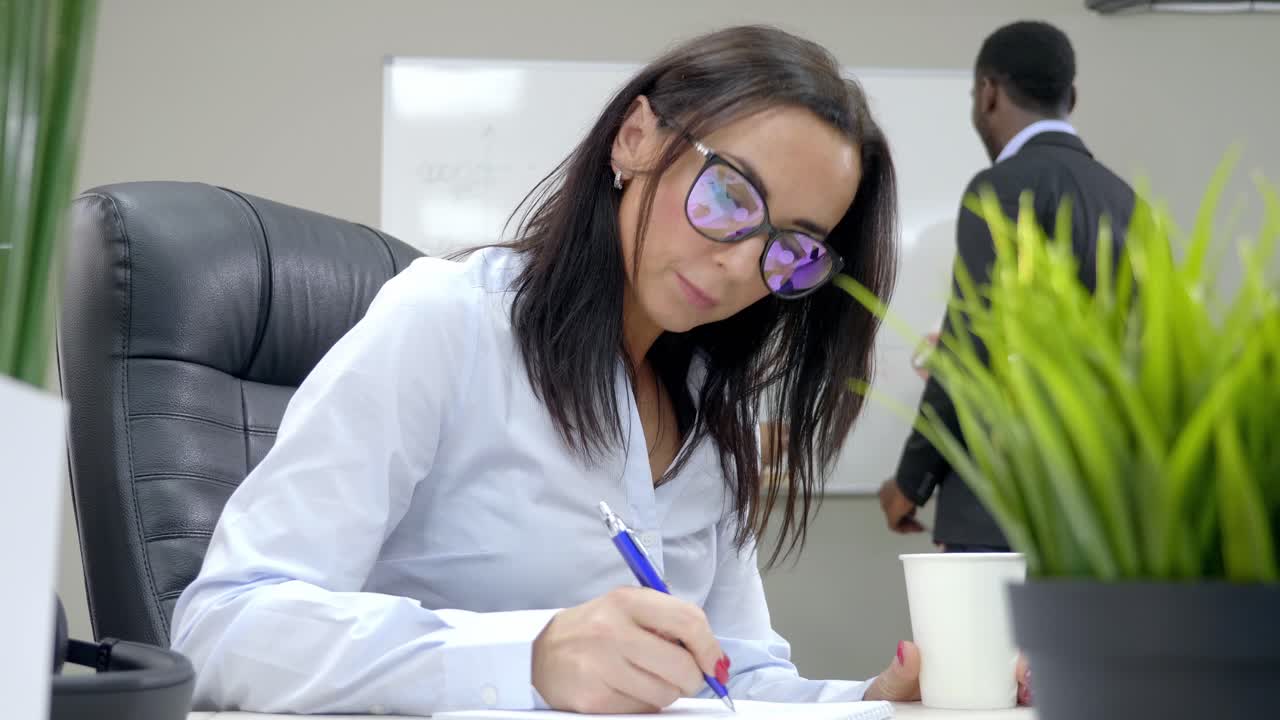 Businesswoman Taking Notes in Meeting