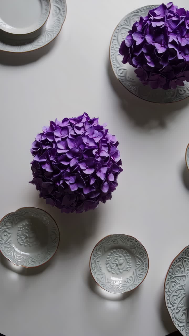 Purple Floral Centerpiece with Decorative Plates on White Table