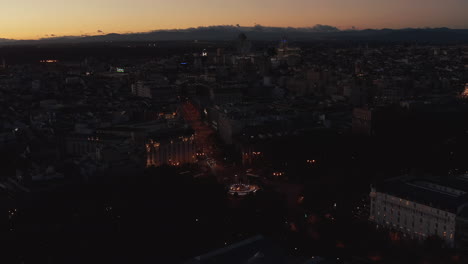 Luftaufnahme-Des-Autos,-Das-Durch-Die-Abendliche-Stadt-Fährt.-Dunkle-Dämmerungsszene-Mit-Hellem-Buntem-Himmel.