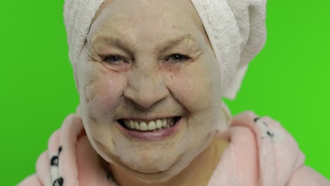 Elderly-grandmother-after-shower.-Old-woman-applying-cosmetic-bubble-face-mask