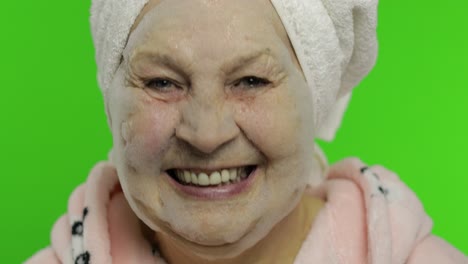 abuela anciana después de la ducha. anciana aplicando máscara facial de burbujas cosméticas
