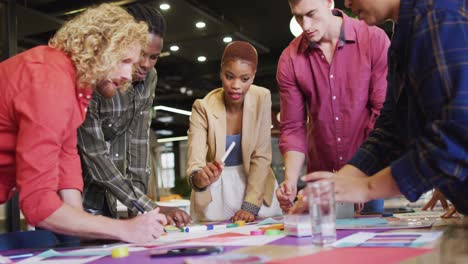 Happy-diverse-business-people-discussing-work-during-meeting-at-office