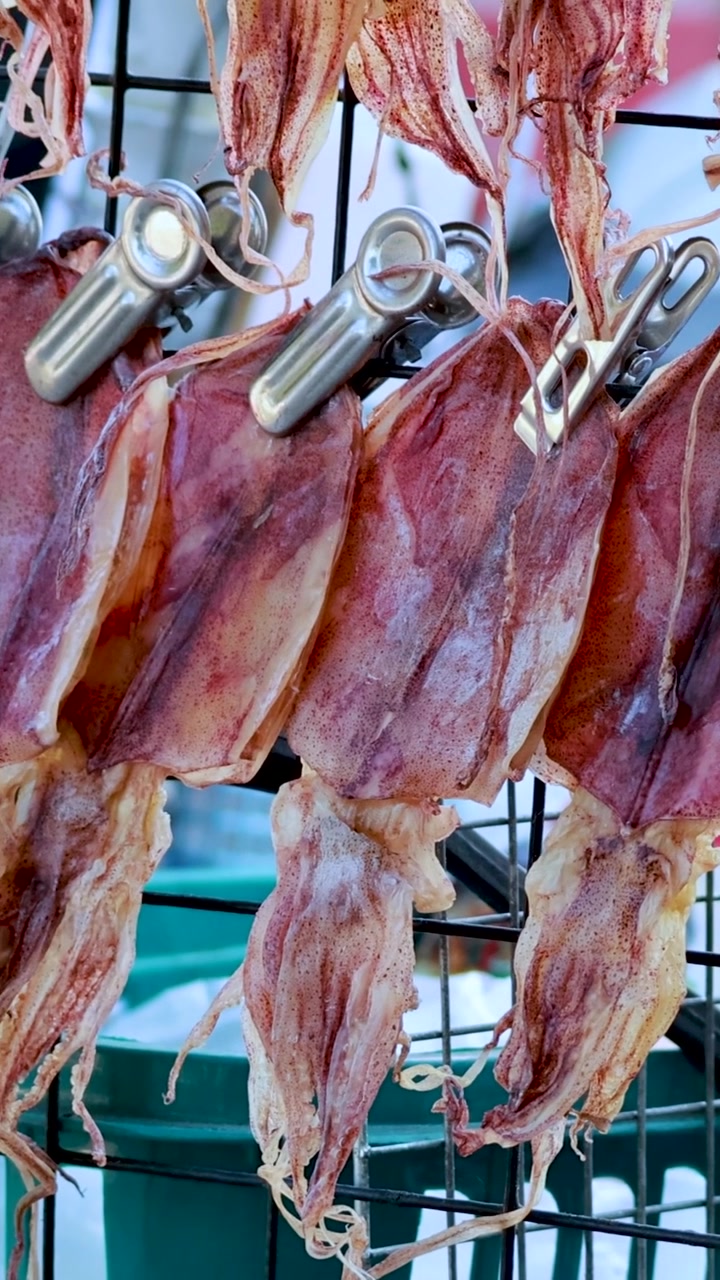 File di calamari essiccati appesi nel mercato di Pattaya