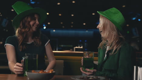 female friends in irish hats celebrating saint patrick's day in a pub 1