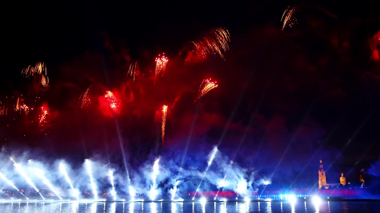 fuegos artificiales coloridos festivos e iluminación en el cielo oscuro con un hermoso reflejo en el agua. velas escarlata de vacaciones