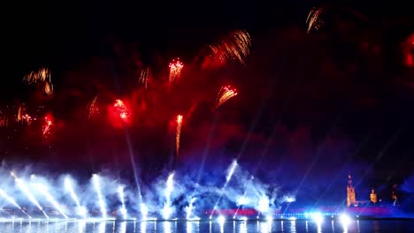 festive colorful fireworks and illumination in dark sky with beautiful reflection in water. holiday scarlet sails