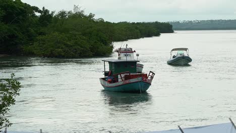 Slow-motion-shot-of-small-fishing-boats-docked-at-the-Tibau-do-Sul-port-on-the-large-Guaraíras-Lagoon-in-Rio-Grande-do-Norte,-Brazil-on-an-overcast-day