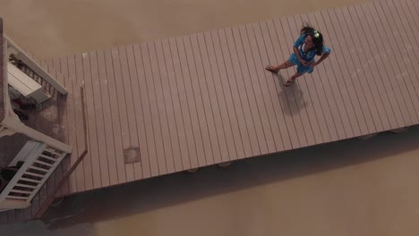 una chica venezolana sexy caminando en un embarcadero durante una filmación de video aéreo