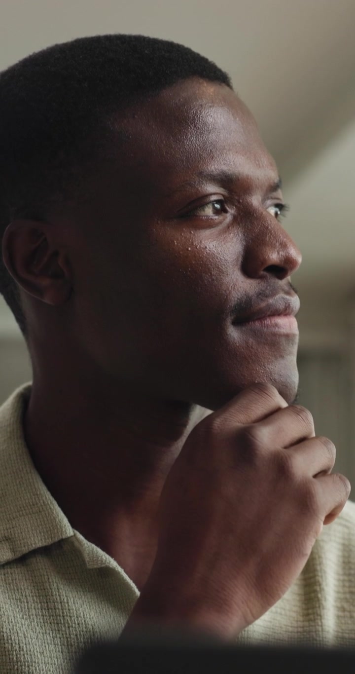 Thoughtful Young Man Looking Away and Touching Chin