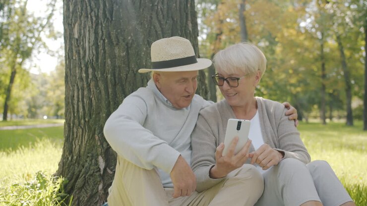 Coppia anziana che usa uno smartphone in un parco