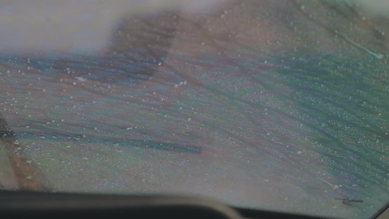 Slow motion close up of fishing boat window showing water spray