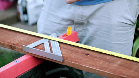 man in slow motion starting woodworking project, taking measurements and preparing wood