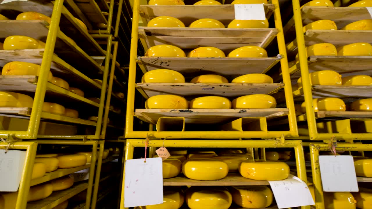 Date labels attached to a cheese wheels rack.